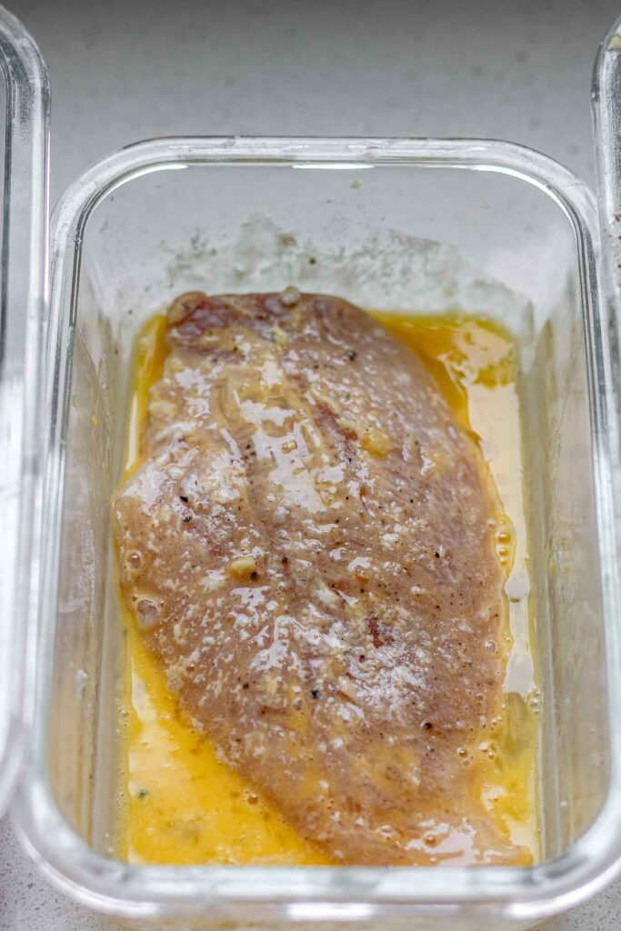 A chicken breast coated in egg.