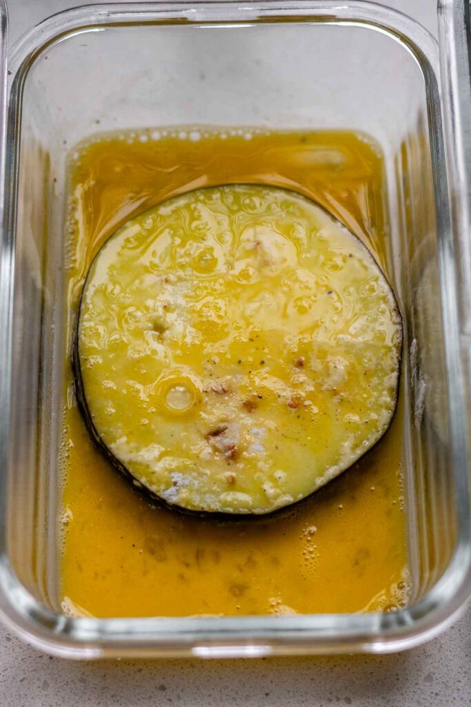 A slice of eggplant coated in egg.