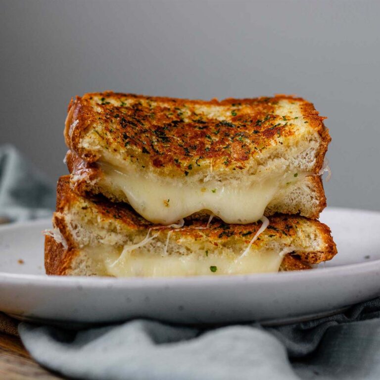 A stacked, halved grilled cheese sandwich.