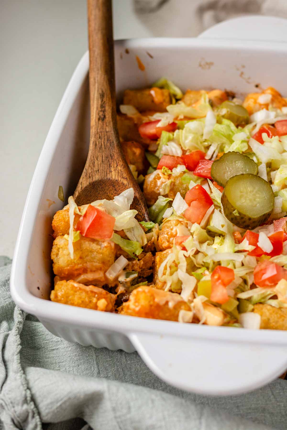Big Mac tater tot casserole with a wooden spoon scooping a portion.