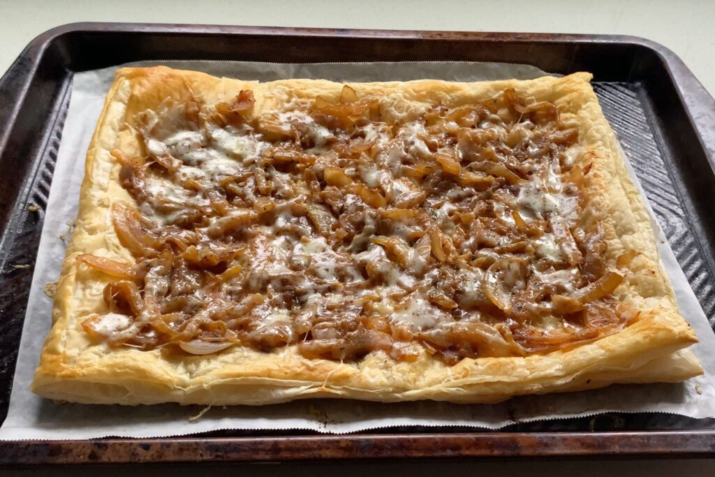Baked puff pastry topped with caramelized onions and melted cheese.
