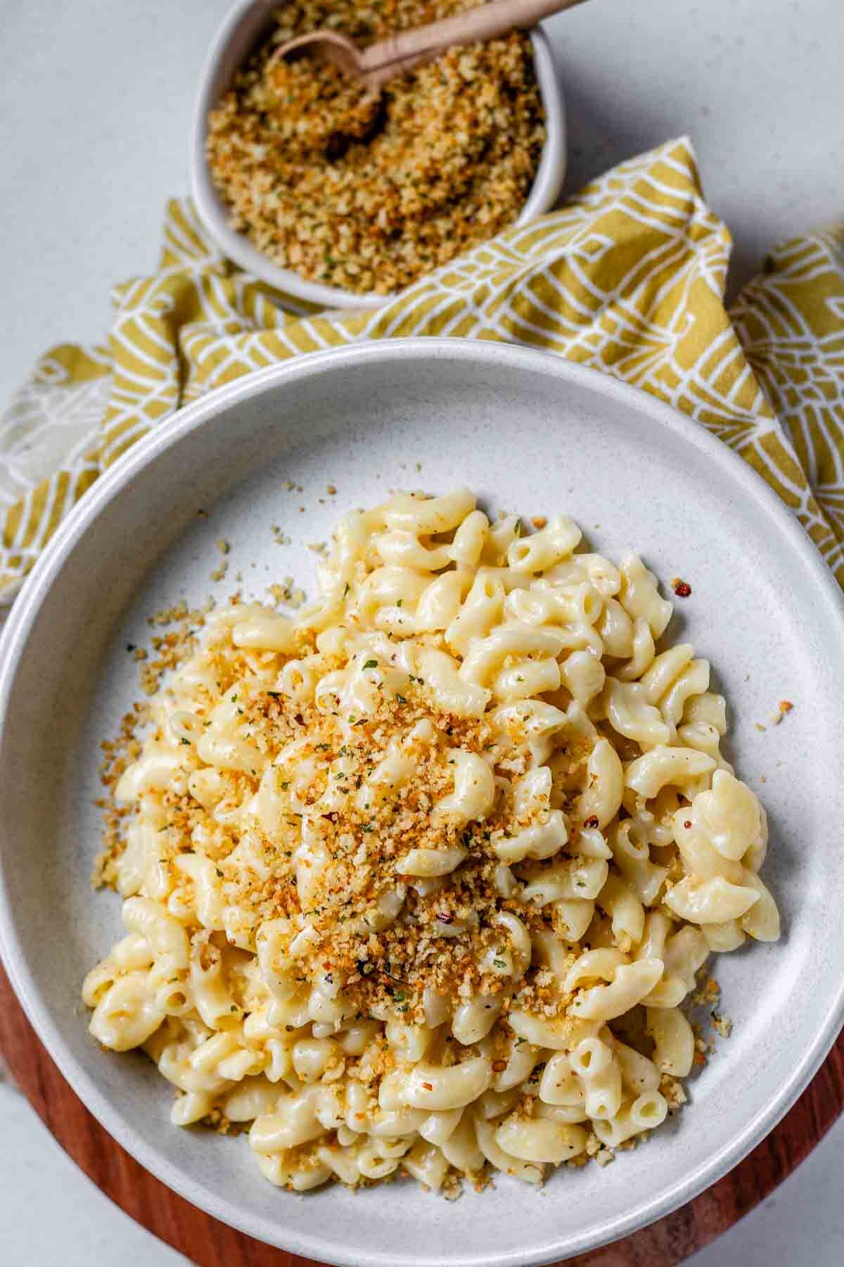Pasta in a bowl topped with breadcrumbs.