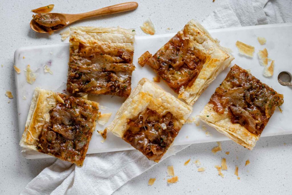 Puff pastry squares topped with caramelized onions and melted cheese.