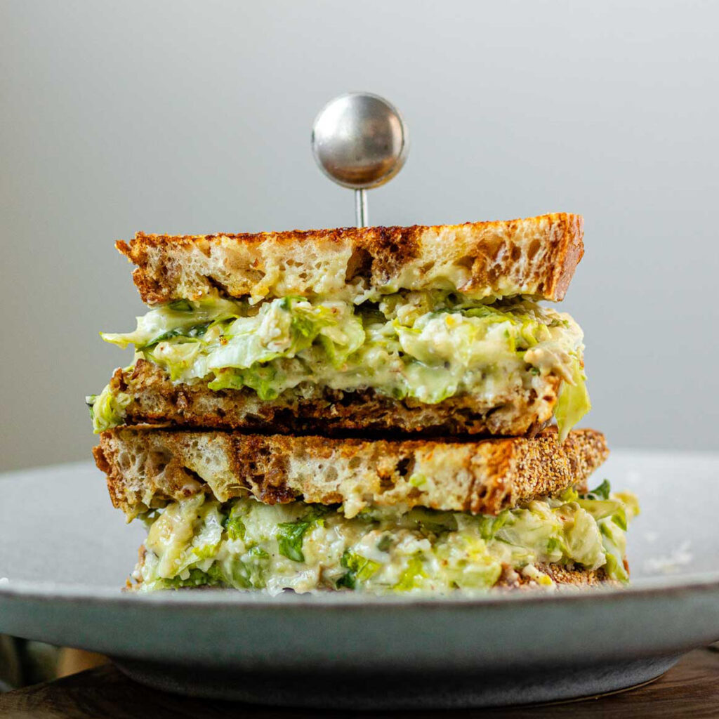 A stacked, halved sandwich with creamy chopped romaine lettuce.