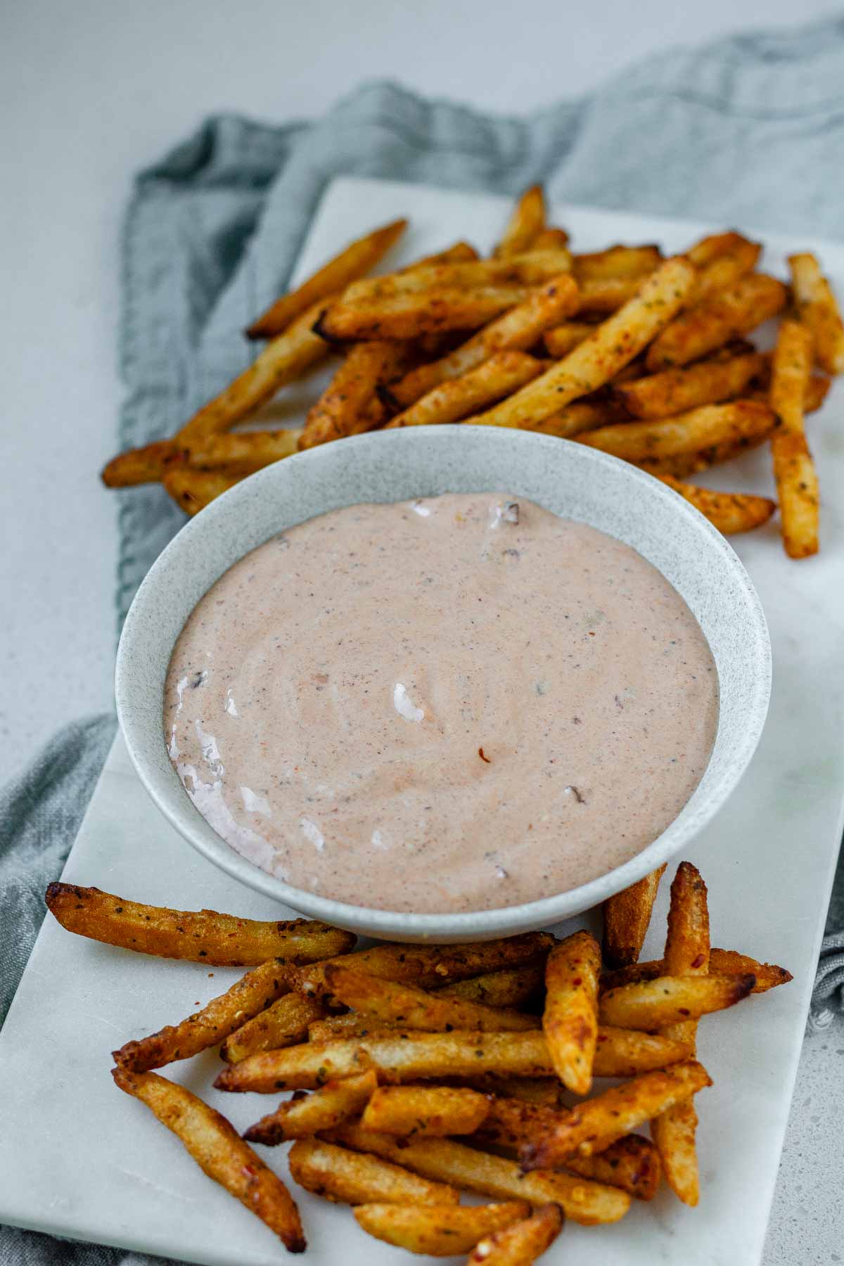 Sauce in a bowl beside french fries.