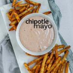 Sauce in a bowl beside french fries with the text chipotle mayo.