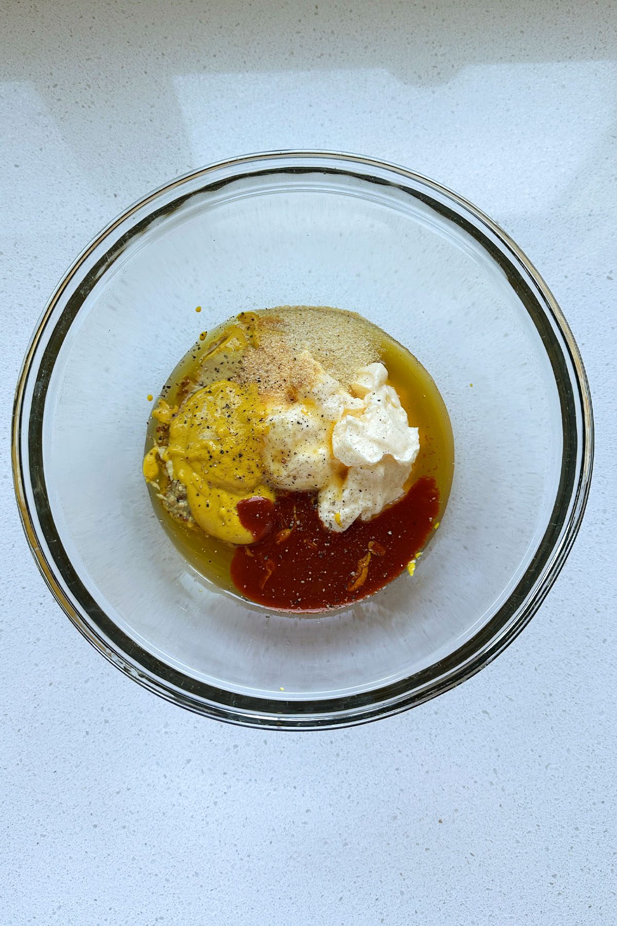 Mayo, mustard, ketchup, honey, and spice in a bowl.