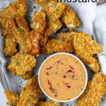 Orange sauce in a bowl surrounded by chicken strips, with the text hot honey mustard.