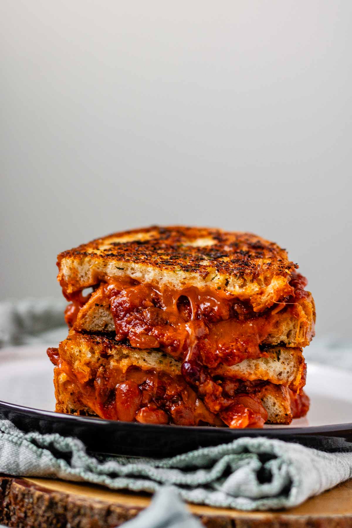 A grilled cheese sandwich with chili oozing out.
