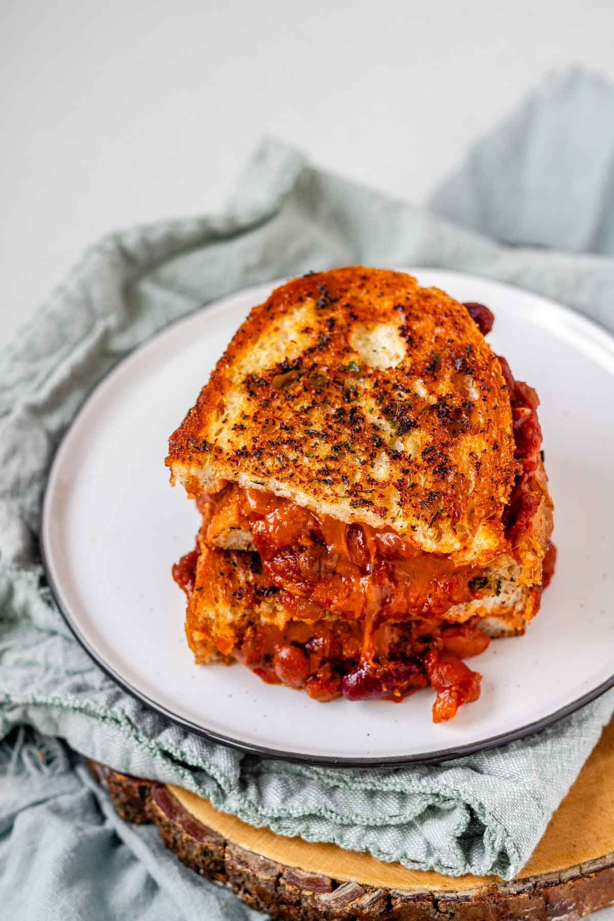 A grilled cheese sandwich with chili oozing out.