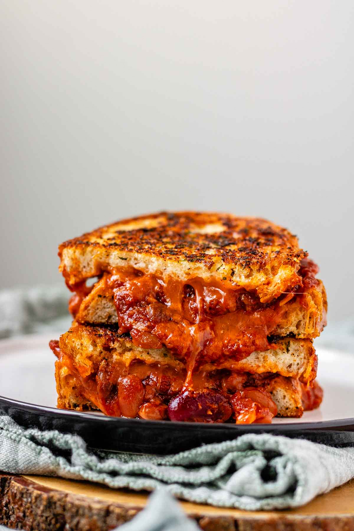 A grilled cheese sandwich with chili oozing out.