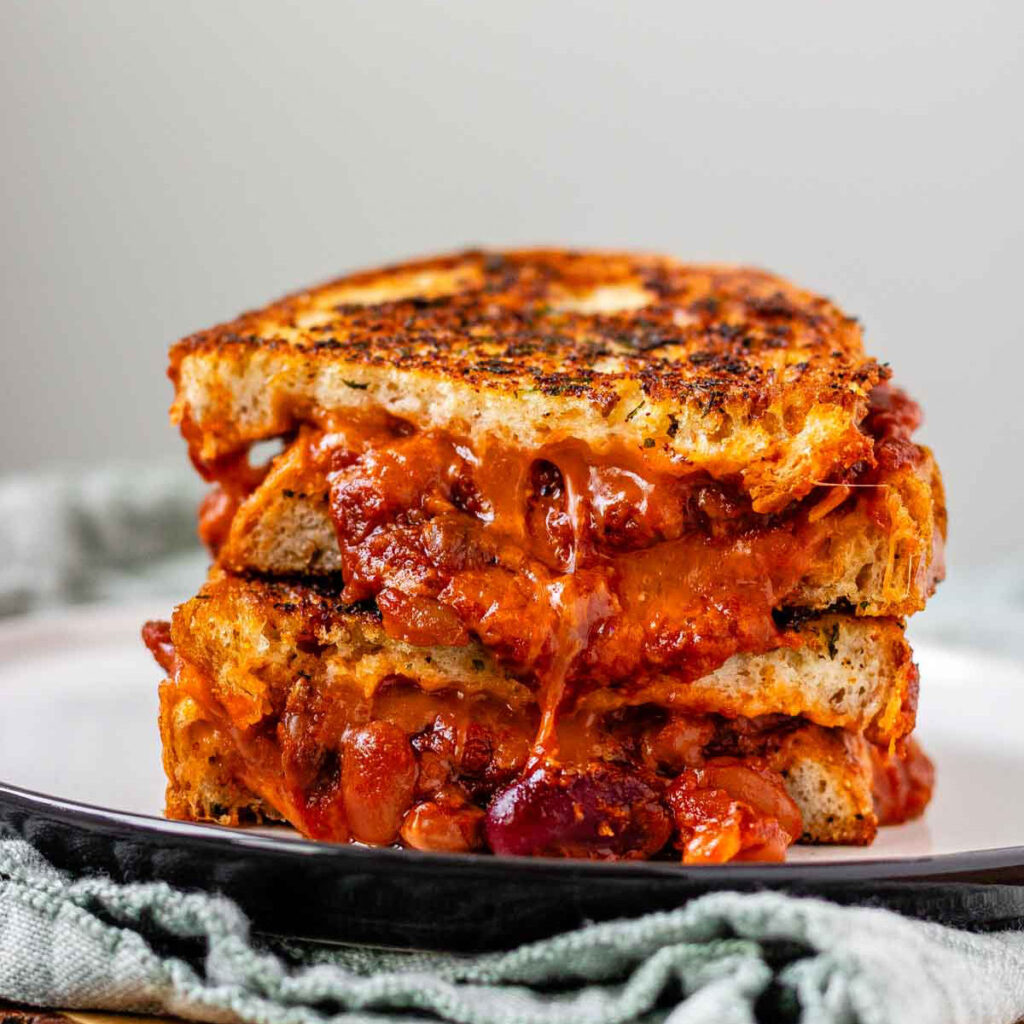 A grilled cheese sandwich with chili oozing out.